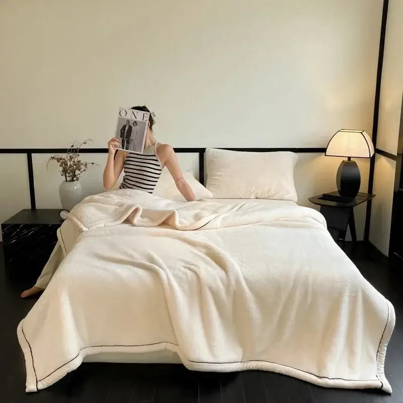 une femme entrain de lire dans son lit avec une couverture en velours douce et moelleuse