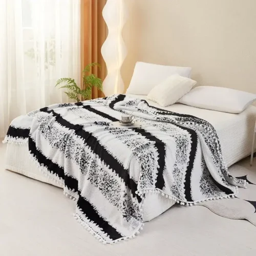 couverture en molleton de lait, flanelle jacquard avec franges bohème sur un lit