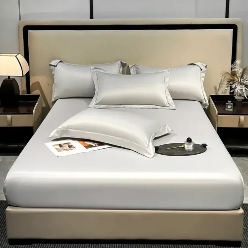 un lit avec un drap housse en soie artificielle d'excellente qualité avec bande élastique et 2 taies d'oreiller