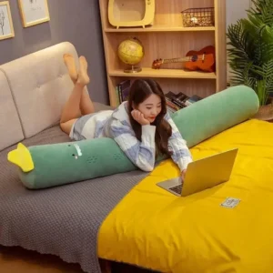 une femme à plat ventre sur son lit avec un oreiller cylindrique mignon pour dormir sur le côté